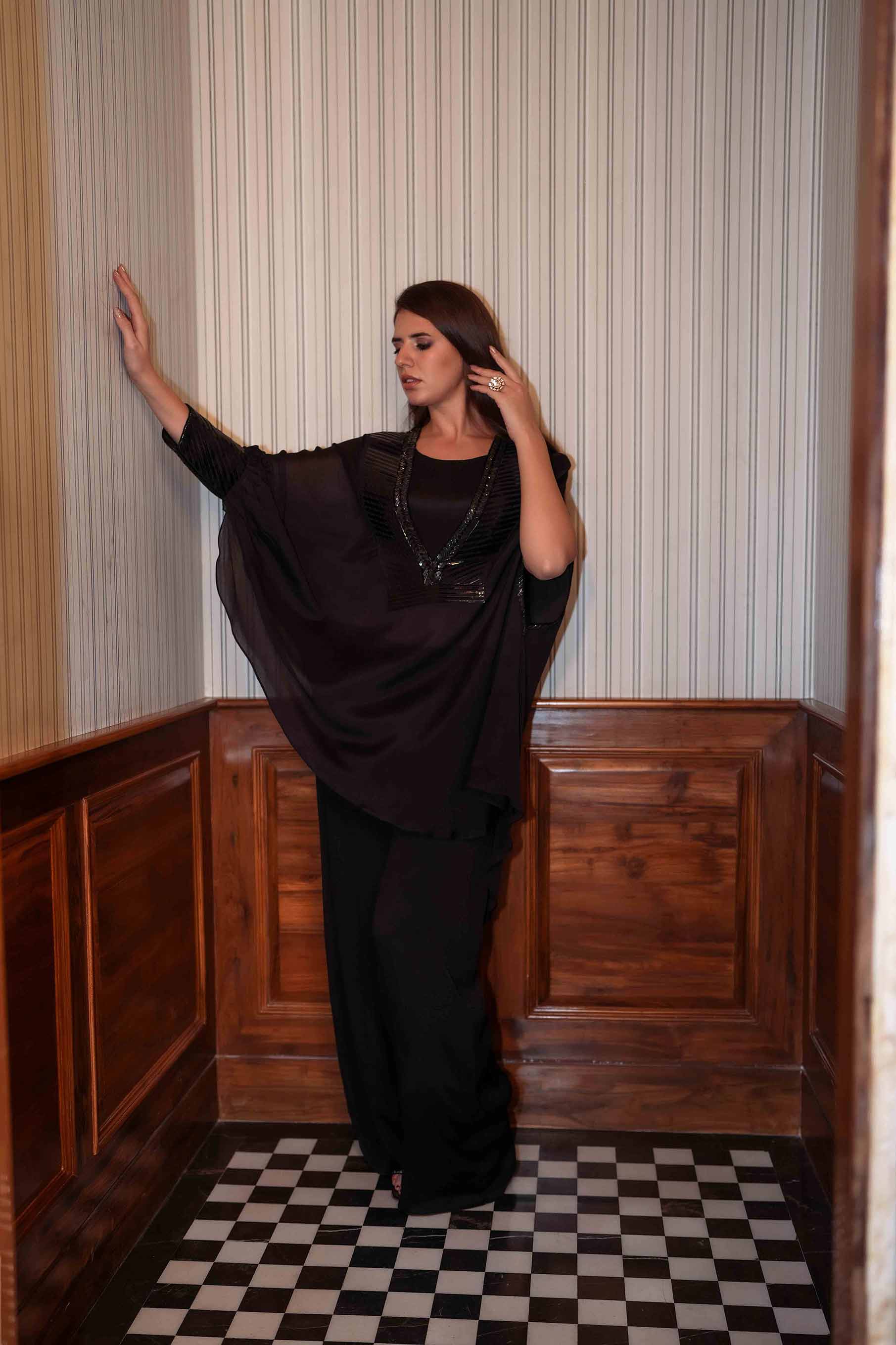 Black crop top with palazzo and stylised cape.