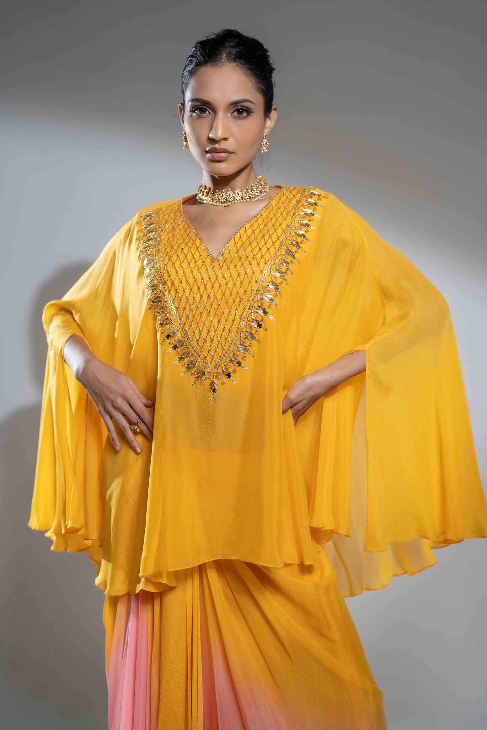 Mustard and pink cape style flowy poncho with draped skirt.
